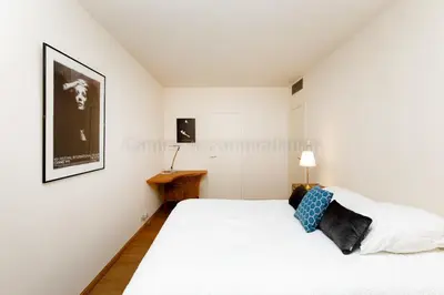 a white bedroom with a bed and a desk at GRAY 4f1 in Cannes