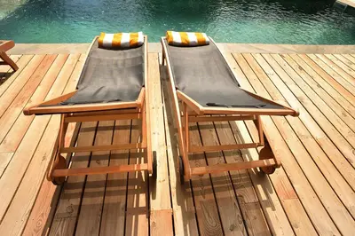 two chairs sitting on a dock next to the water at La Villa d’Emma in Mougins