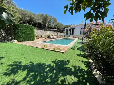 a backyard with a swimming pool and a wooden deck at La Villa d’Emma in Mougins
