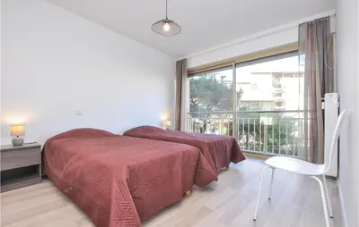 a bedroom with two beds and a large window at 2 Bedroom Amazing Apartment In Cannes in Cannes