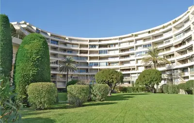 a large apartment building with a lawn and trees at 2 Bedroom Amazing Apartment In Cannes in Cannes