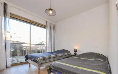 a bedroom with two beds and a large window at 2 Bedroom Amazing Apartment In Cannes in Cannes
