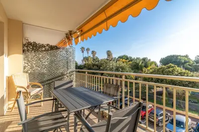 a patio with a table and chairs on a balcony at Le Mistral - Appt avec deux balcons à Cannes in Cannes