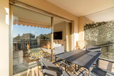 a patio with a table and chairs on a balcony at Le Mistral - Appt avec deux balcons à Cannes in Cannes