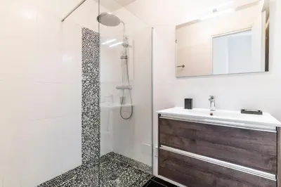 a bathroom with a shower and a sink and a mirror at Le Mistral - Appt avec deux balcons à Cannes in Cannes