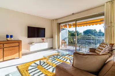 a living room with a couch and a glass table at Le Mistral - Appt avec deux balcons à Cannes in Cannes