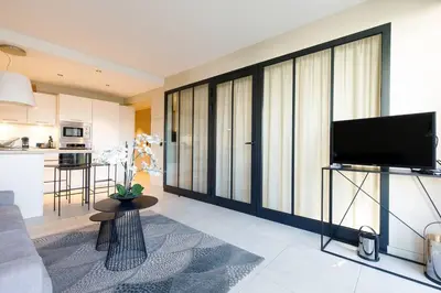 a living room with a television and a kitchen at Marriott area superb 1 bedroom in Cannes
