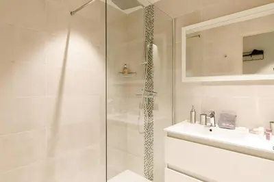 a white bathroom with a shower and a sink at Marriott area superb 1 bedroom in Cannes