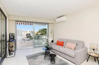a living room with a couch and a large window at Marriott area superb 1 bedroom in Cannes