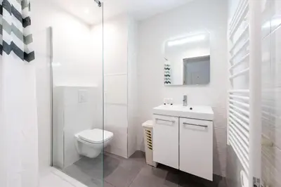 a white bathroom with a toilet and a sink at LE NID DU SUQUET une escapade idéale pour couples, près commerces, Palais et plages in Cannes