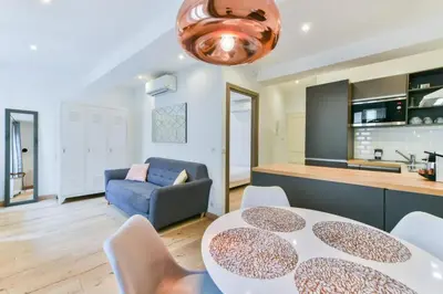 a kitchen and a living room with a table and chairs at LE NID DU SUQUET une escapade idéale pour couples, près commerces, Palais et plages in Cannes