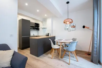 a kitchen and dining room with a table and chairs at LE NID DU SUQUET une escapade idéale pour couples, près commerces, Palais et plages in Cannes