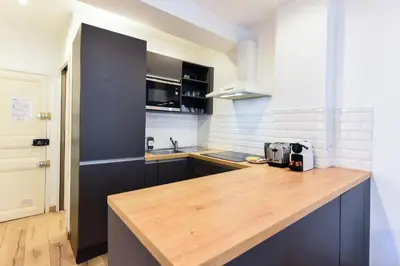 a kitchen with a wooden counter top in a room at LE NID DU SUQUET une escapade idéale pour couples, près commerces, Palais et plages in Cannes