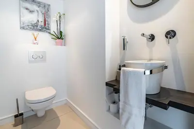 a white bathroom with a toilet and a sink at Cannes centre dernier étage in Cannes