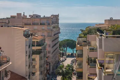 a city street with buildings and the ocean in the background at Cannes centre dernier étage in Cannes