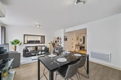 a dining room and living room with a table and chairs at Appartement Sauvalie - Welkeys in Le Cannet