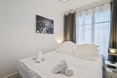 a white bed with white pillows and a window at Appartement Sauvalie - Welkeys in Le Cannet