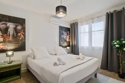 a bedroom with a large white bed and a window at Appartement Sauvalie - Welkeys in Le Cannet