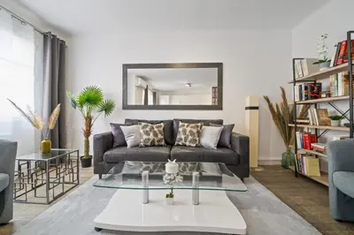 a living room with a couch and a mirror at Appartement Sauvalie - Welkeys in Le Cannet