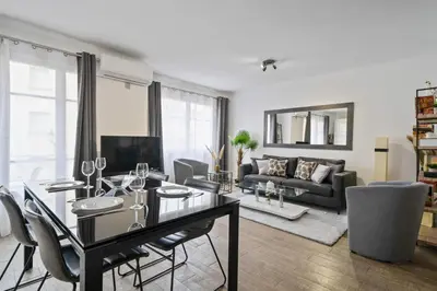 a living room with a black table and chairs at Appartement Sauvalie - Welkeys in Le Cannet