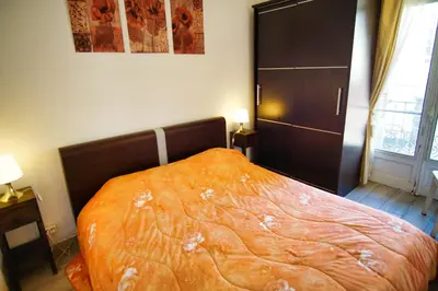 a bedroom with a bed with an orange blanket at Ref JOFFRE - Palmes d'Or Properties in Cannes