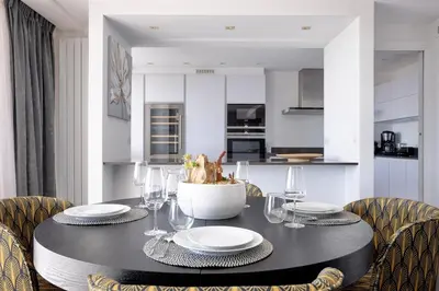a dining room with a black table and chairs at Cannes Panorama - Piscine, vue mer, parking, clim in Cannes