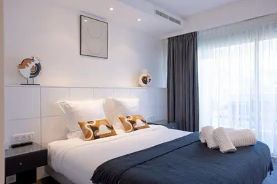 a bedroom with a bed with two pairs of shoes on it at Cannes Panorama - Piscine, vue mer, parking, clim in Cannes