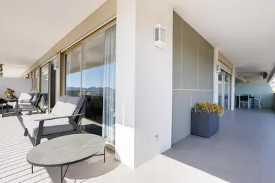 a balcony with chairs and a table on a building at Cannes Panorama - Piscine, vue mer, parking, clim in Cannes