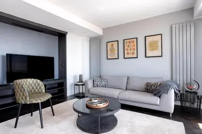 a living room with a couch and a tv at Cannes Panorama - Piscine, vue mer, parking, clim in Cannes