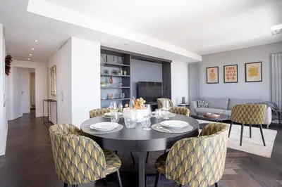 a dining room and living room with a table and chairs at Cannes Panorama - Piscine, vue mer, parking, clim in Cannes