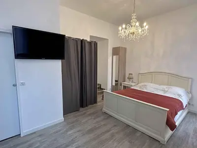 a bedroom with a bed and a flat screen tv at Cannes Studio situé dans la résidence Gallia Historique in Cannes