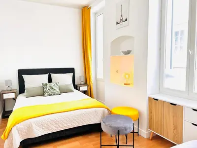 a bedroom with a bed with a yellow blanket and a stool at 1 Bedroom flat with Balcony Cannes Center Croisette 6ppl in Cannes