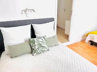a bed with white pillows and a headboard with at 1 Bedroom flat with Balcony Cannes Center Croisette 6ppl in Cannes