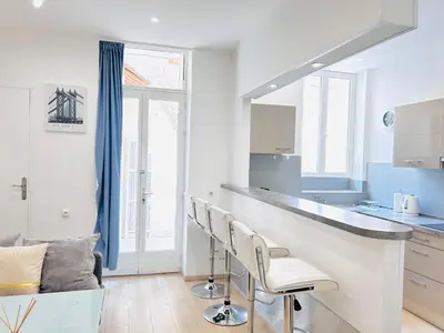 a kitchen with a counter and chairs in a room at 1 Bedroom flat with Balcony Cannes Center Croisette 6ppl in Cannes