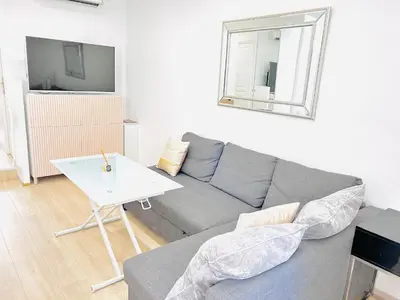 a living room with a gray couch and a white table at 1 Bedroom flat with Balcony Cannes Center Croisette 6ppl in Cannes