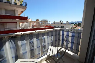 a balcony with a white chair on a building at Charming Stanislas Studio with Wi-Fi and Air Conditioning in Cannes