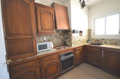 a kitchen with wooden cabinets and a microwave at Charming Stanislas Studio with Wi-Fi and Air Conditioning in Cannes