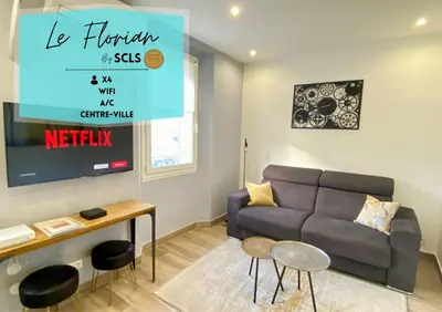 a living room with a couch and a tv at Le Florian By SCLS Locations in Cannes