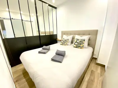 a large white bed with two pillows on it at Le Florian By SCLS Locations in Cannes