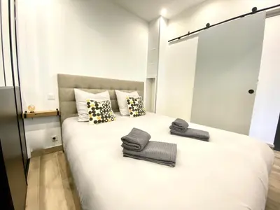 a bedroom with a large white bed with towels on it at Le Florian By SCLS Locations in Cannes