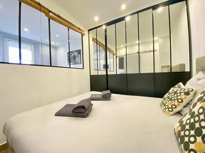 a bedroom with a large white bed with windows at Le Florian By SCLS Locations in Cannes