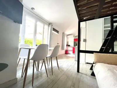 a dining room with white chairs and a table at Maisonnette Studio bas Suquet, proche plage et palais in Cannes