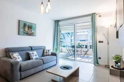 a living room with a couch and a table at 1-Br apartment in Palm Beach swimming pool in Cannes
