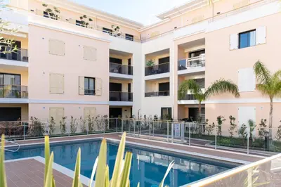 an apartment building with a swimming pool and palm trees at 1-Br apartment in Palm Beach swimming pool in Cannes