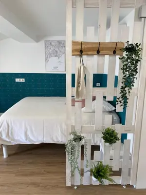 a bedroom with a bed with a wall with plants at Studio centre ville cannes in Cannes