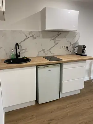 a kitchen with white cabinets and a counter top at Studio centre ville cannes in Cannes