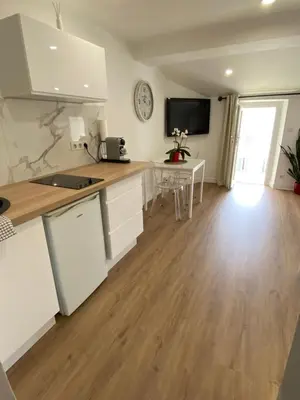 a kitchen with white cabinets and a table in a room at Studio centre ville cannes in Cannes