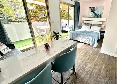 a room with a table and chairs and a bedroom at Butterfly-Palais des Festival-center-quiet-AC-Wi Fi parking in Cannes