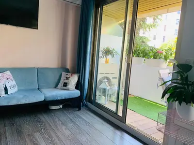 a living room with a blue couch and a sliding glass door at Butterfly-Palais des Festival-center-quiet-AC-Wi Fi parking in Cannes