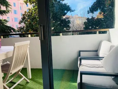 a patio with a table and chairs on a balcony at Butterfly-Palais des Festival-center-quiet-AC-Wi Fi parking in Cannes